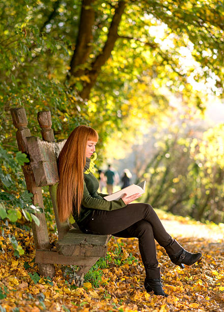 istock Woman reading in the autumn nature 451078159