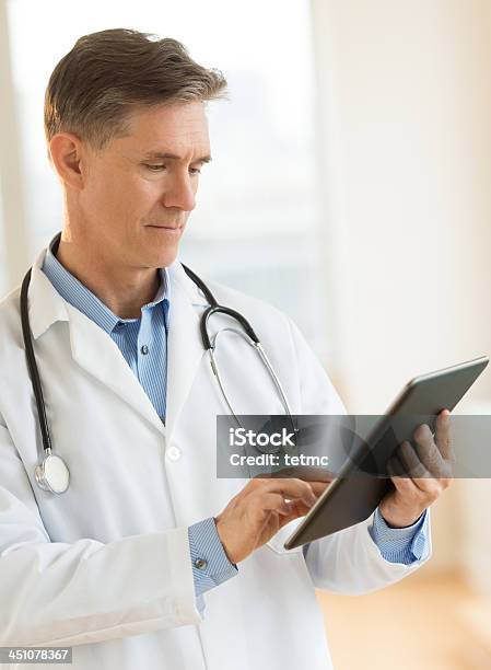 Male Doctor Holding Digital Tablet Stock Photo - Download Image Now - Digital Tablet, Doctor, 40-44 Years