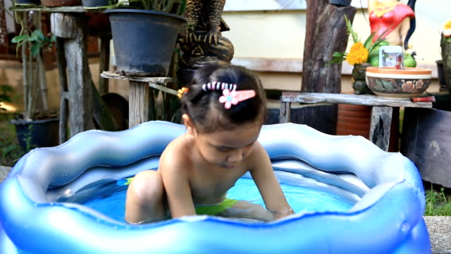asia girl  playing in a paddling pool