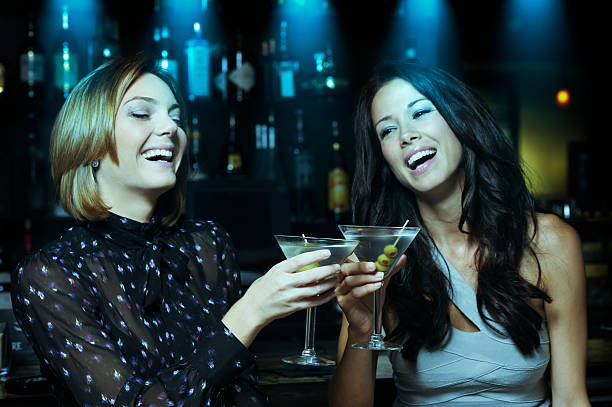 istock Two Young Women Toasting Drinking Martinis in Bar 451133083