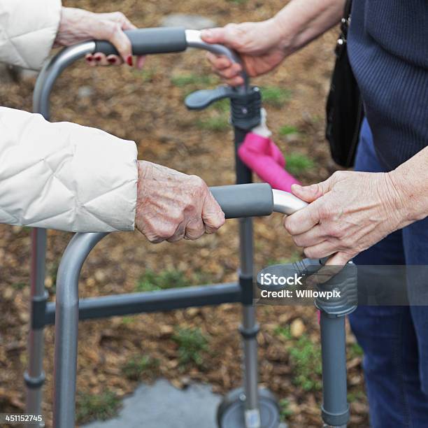 Пожилые Женщина И Лицо Осуществляющее Уход Оказание Помощи В Ортопедические Walker — стоковые фотографии и другие картинки Дождь