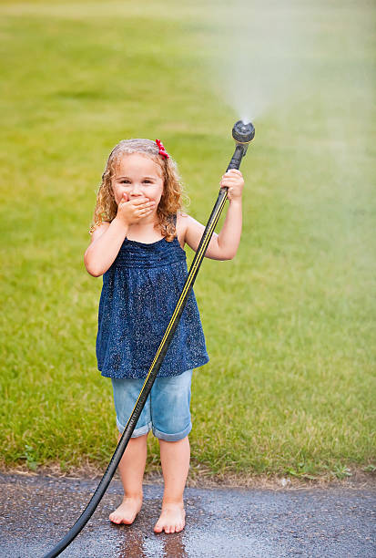 istock Girl Playing With Garden Hose 451166633