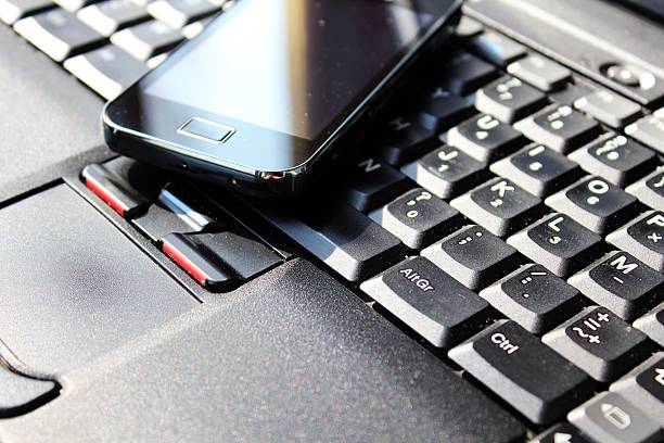 istock Smart phone on the keyboard of laptop 451172113