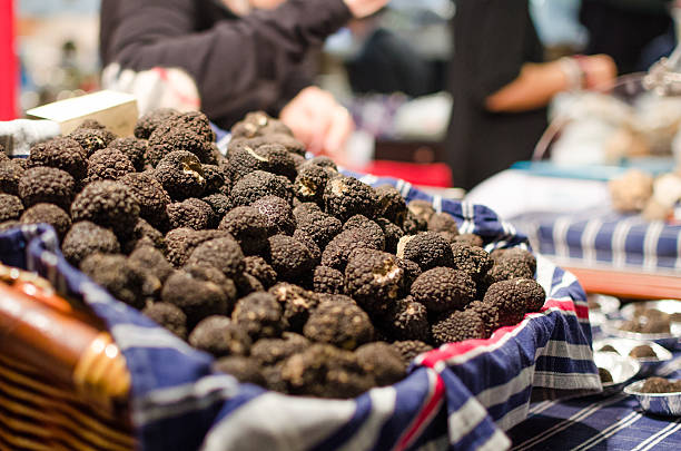 A large pile of truffles in a lined basket on a blue table A lot of black truffles at the international Truffle Fair 2013 in Alba, Piedmont, Italy piedmont italy photos stock pictures, royalty-free photos & images
