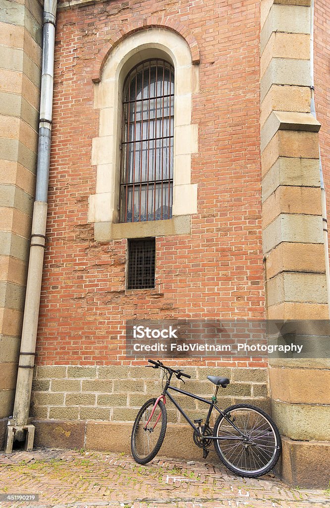 Vélo appuyé sur l'ancienne muraille de briques rouges - Photo de Architecture libre de droits