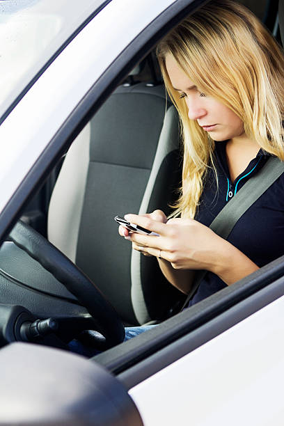 istock Woman with mobile phone while driving 451257029