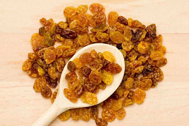 istock raisins in wooden scoop 451258521