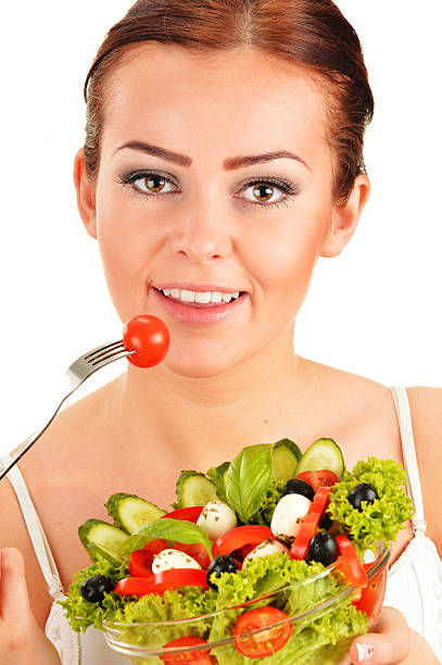 istock Young woman eating vegetable salad 451275079