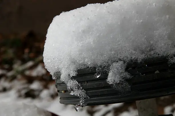 Snow covering a wheel of a kids wagen.