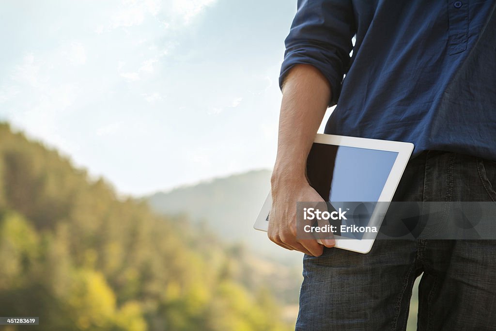 Man holds digital tablet Man holds digital tablet on nature Adult Stock Photo