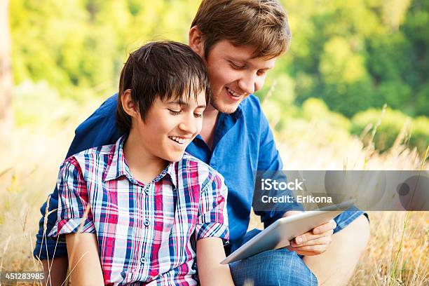 Man And Boy Using Digital Tablet Stock Photo - Download Image Now - Adult, Blogging, Boys