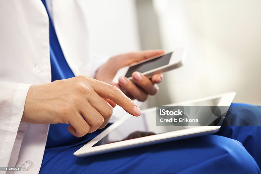 Doctor touching digital tablet Doctor touching screen digital tablet and holds smart phone Close-up Stock Photo