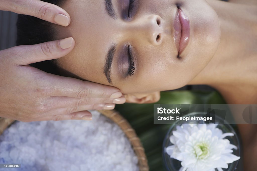 Refreshed beauty A beautiful young woman having a spa treatment Facial Massage Stock Photo