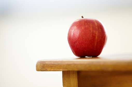 Closeup shot of a red apple on a desk