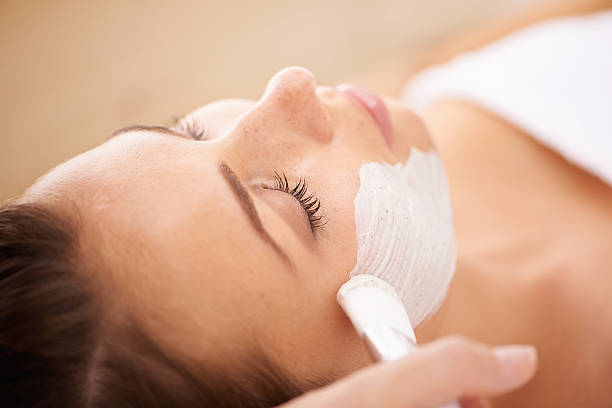 This is going to be a deep cleanse Closeup of a beauty therapist applying a face mask to a client facial mask stock pictures, royalty-free photos & images