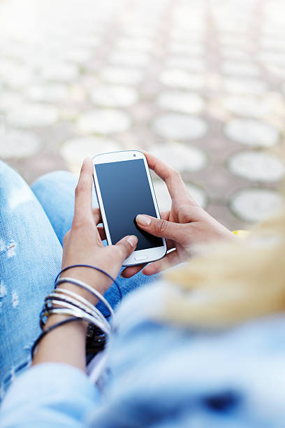 Young woman in denim clothes using smart phone