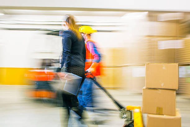 istock Worker and female manager in busy warehouse speedy working action 451304009