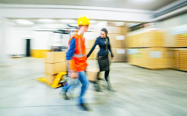 istock Worker and female manager in busy warehouse speedy working action 451304021