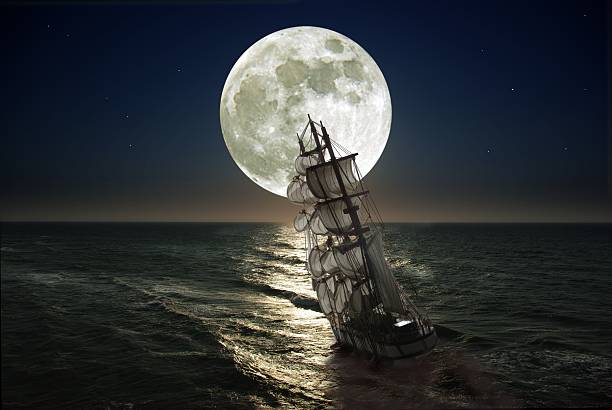 istock Ship with sails leaning in sea as moon rises 451343873
