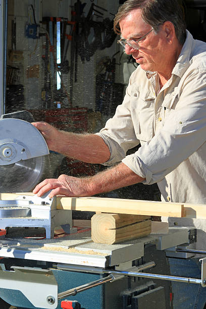 Miter Saw Using the miter saw to cut 45 degree angles for framing. miter saw stock pictures, royalty-free photos & images