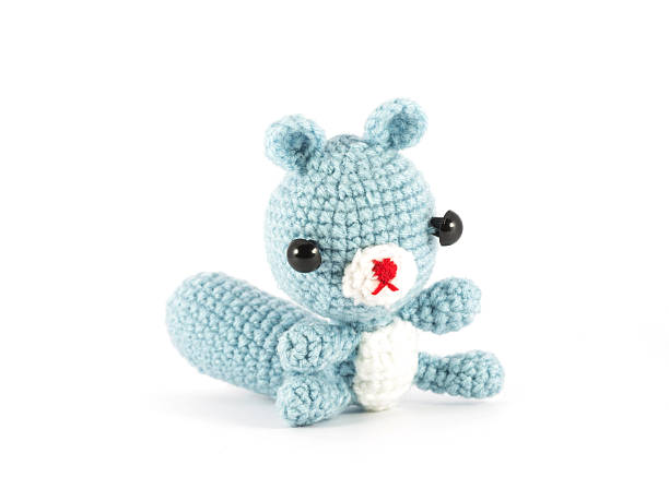 istock handmade crochet Raccoon doll on white background 451347773
