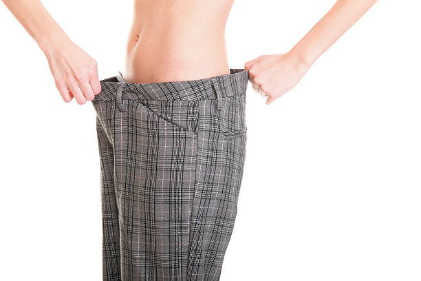 istock Woman showing how much weight she lost 451360885
