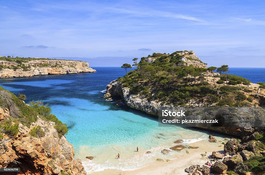 Young couple playing in water at beautiful beach View of Cala des Moro beach and its azure blue water, Majorca island, Spain Majorca Stock Photo