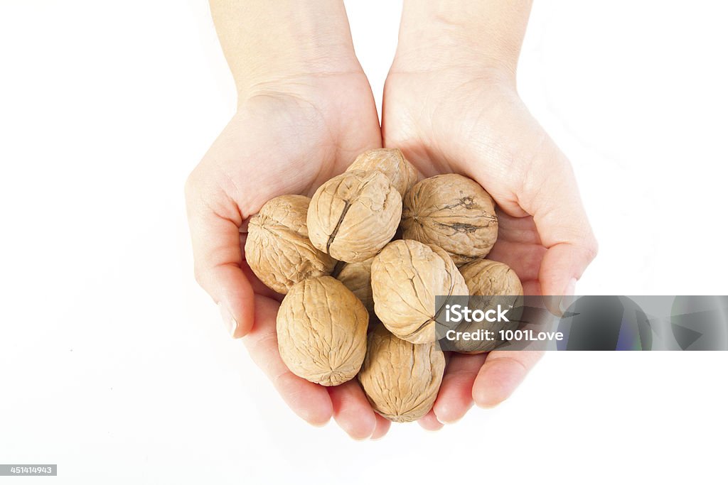 Manos sosteniendo una walnut sobre blanco - Foto de stock de Agarrar libre de derechos