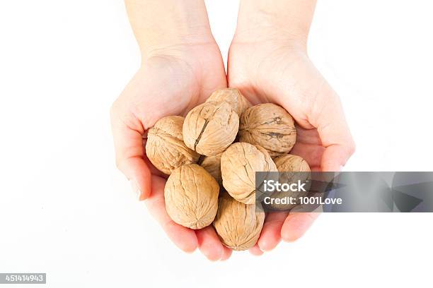 Foto de Mãos Segurando Um Walnut No Branco e mais fotos de stock de Alimentação Saudável - Alimentação Saudável, Antioxidante, Casca de Noz