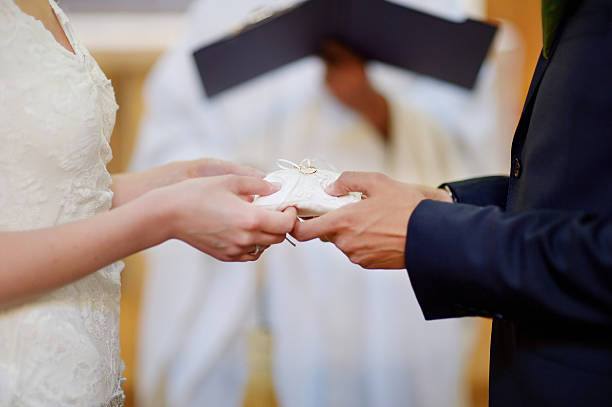 istock Bride and groom's hands holding wedding rings 451417063