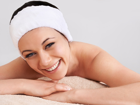 Cropped view of a young woman smiling while lying in a day spa