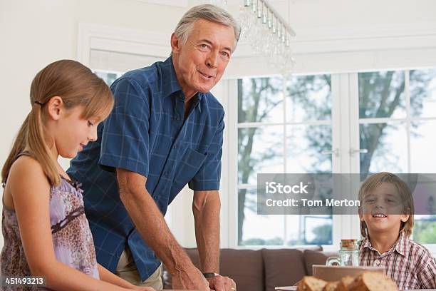 Photo libre de droit de Homme Et Deux Enfants À La Table De Salle À Manger banque d'images et plus d'images libres de droit de Hommes seniors - Hommes seniors, 10-11 ans, 4-5 ans