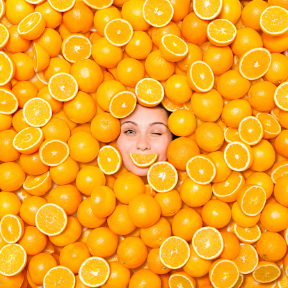 Woman Winking Surrounded With Oranges