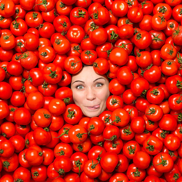 Woman Making Funny Face Surrounded With Tomatoes