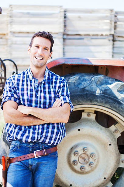 istock Tractor and farmer in a field. 451530177