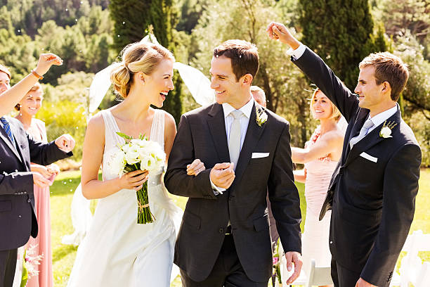 istock Guests Throwing Confetti On Couple During Outdoor Wedding 451530371