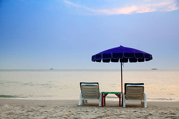 istock Tropical beach with chairs and parasol 451537893