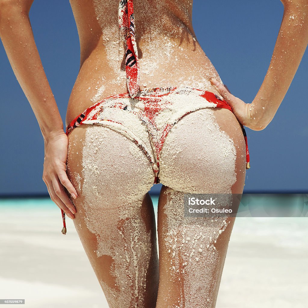 Sexy sandy woman buttocks on the beach background Buttocks Stock Photo