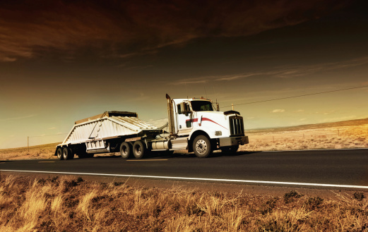 Agregate truck on desert highway in Arizona, USA. Note to inspector: Sunset light and slightly color manipulation.