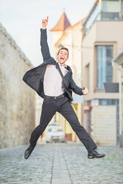 istock Young handsome man in formal wear jumping up 451571917