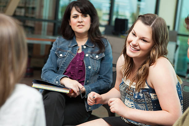 istock Teen girl talking during group counseling session 451572047
