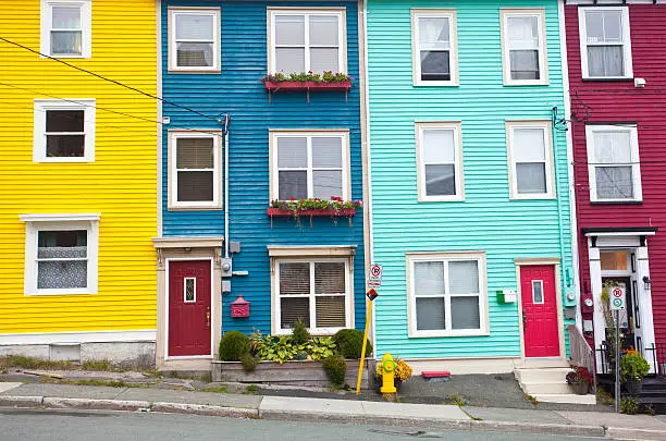 Colourful houses in St. John's, Newfoundland. Jellybean district. This neighborhood in the city is famous for its colourful row houses and unique architecture. The district is located just off the waterfront and the famous St. John's Harbour. 