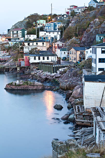 Old Fishing Village at Night in Newfoundland A quaint fishing village in Newfoundland, Canada. Queen's Battery, St. John's. A vertical colour image of an iconic and idyllic little fishing port in Newfoundland. This remarkable little row of houses sit along St. John's Harbour and are nestled into the port city of St. John's. This image was taken just before sunrise, just as the photographer was making his way up to the top of Signal Hill!  st. johns newfoundland photos stock pictures, royalty-free photos & images
