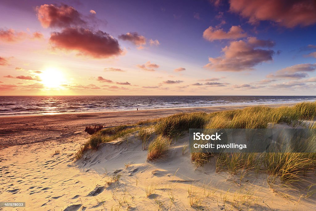 Seaside with sand dunes at sunset Seaside with sand dunes and colorfull sky at sunset Beach Stock Photo