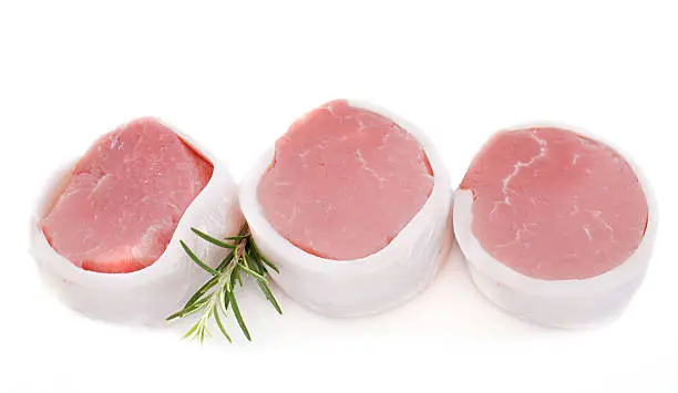 veal tournedos in front of white background