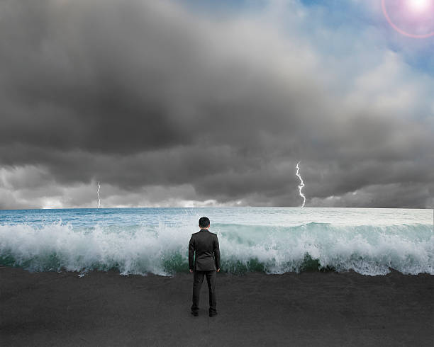 istock Businessman standing toward waves and cloudy sky with Lightning 451587515