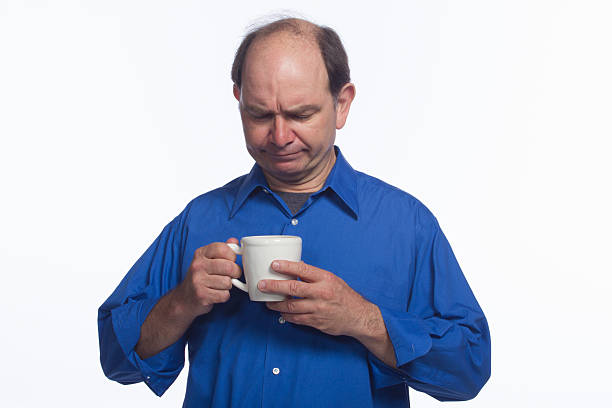 istock Man looking into his cup of coffee, horizontal 451588457