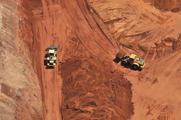 istock Heavy bulldozer loading red sand, an aerial view 451589893