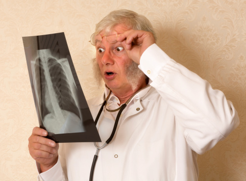 Vintage doctor examining an x-ray and looking surprised