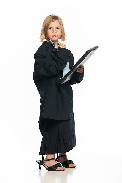 Female Child in Oversized Business Suit Holding a Clipboard stock photo